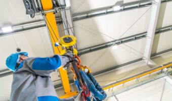 Ceiling Mounted Crane Lift Caucasian Operator. Industrial Technologies. Warehouse Lifting Equipment.