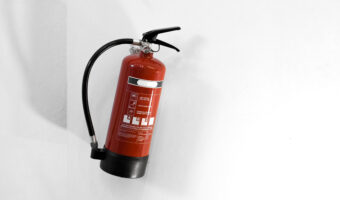 Red fire extinguisher on a white wall