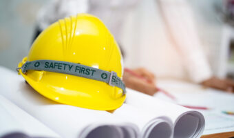 Yellow helmet with blueprint : engineer safety concept.